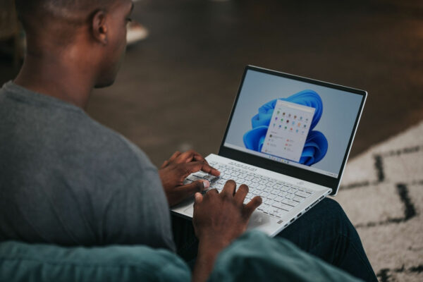 Person, die auf der Couch an einem Windows 11 Computer arbeitet Windows 11 Upgrade vorbereiten und durchführen